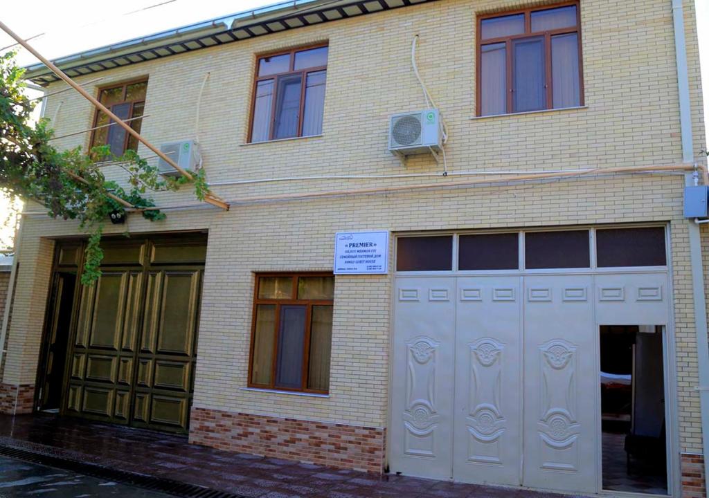 un edificio de ladrillo con una puerta de garaje blanca en Premier, en Samarkand