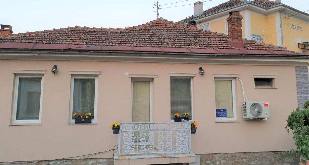 a house with a balcony with flowers on it at Alex Apartments in Kruševo