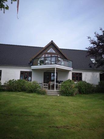 una gran casa blanca con techo de gambrel en Hvirrekærgaard, midt i naturen., en Hirtshals