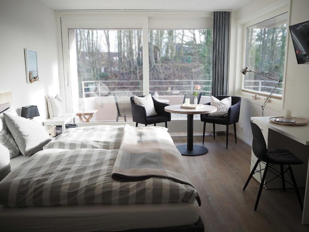グリュックスブルクにあるAppartement Auszeitのベッドルーム1室(ベッド1台、テーブル、椅子付)