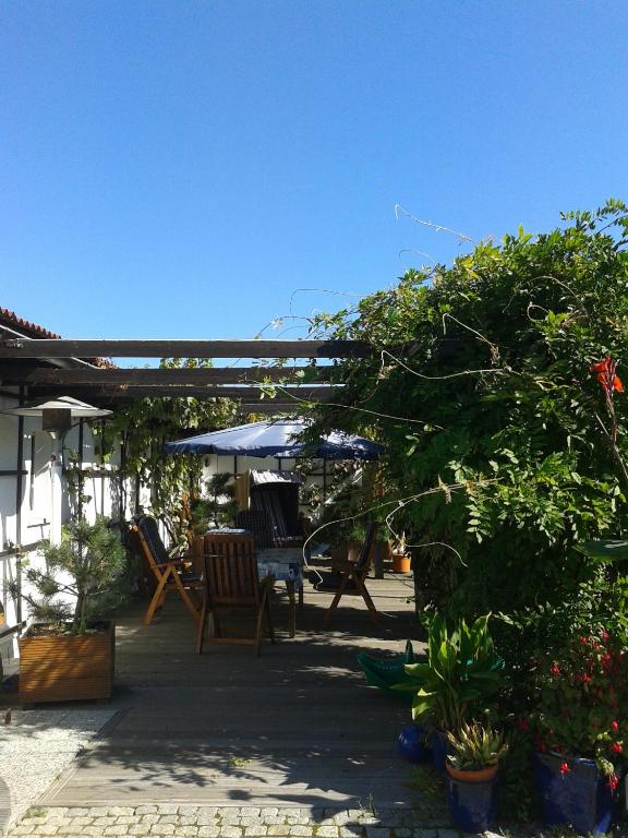 a patio with a table and chairs and an umbrella at Pension Fennert in Pritzwald