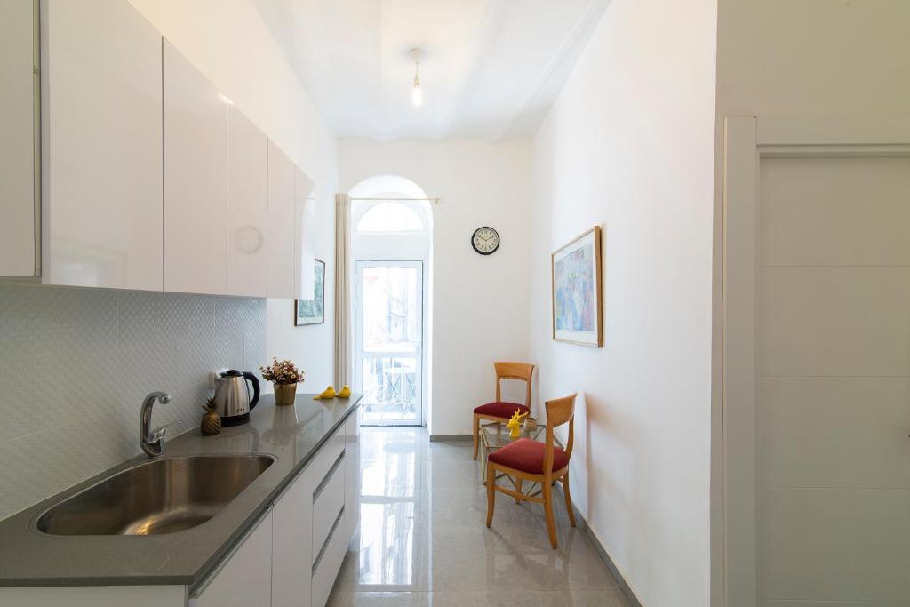 a kitchen with white cabinets and a sink at Habira Apartments in Jerusalem