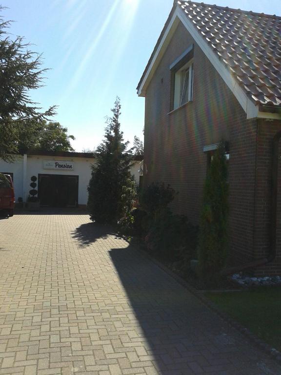 a house with a driveway in front of a garage at Pension Fennert in Pritzwald