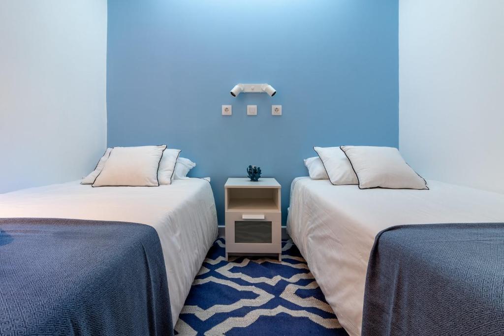 2 łóżka w pokoju z niebieską ścianą w obiekcie Flatguest Villa Yaiza w mieście San Bartolomé