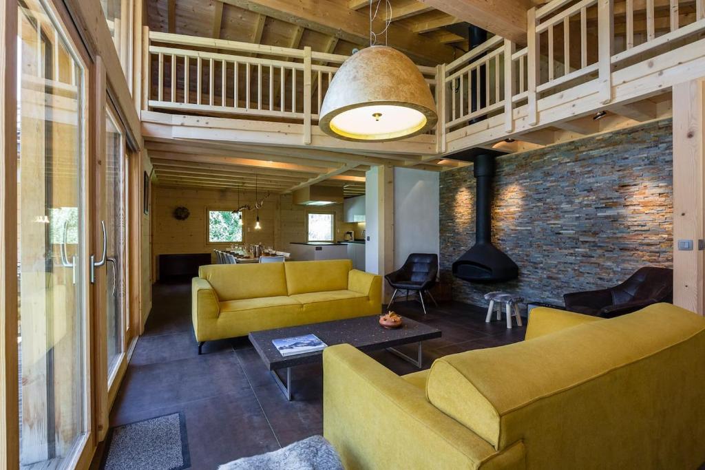 a living room with yellow furniture and a brick wall at Superbe chalet-11 personnes-Chamonix(Les Bossons) in Chamonix-Mont-Blanc