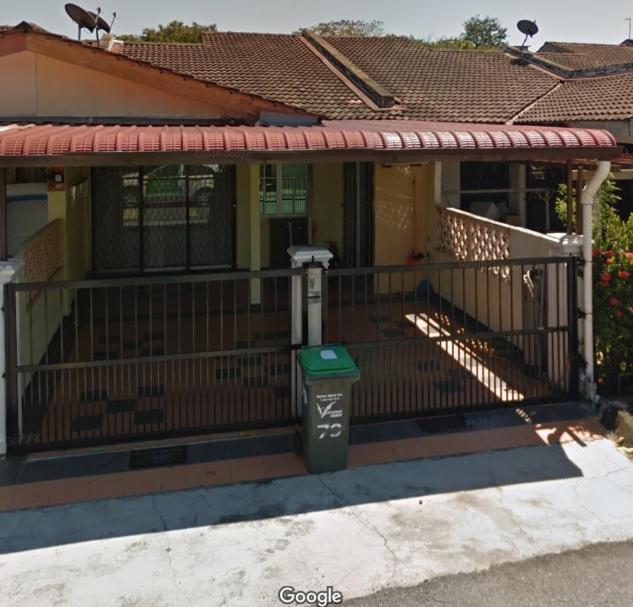 a house with a gate and a trash can in front of it at Pandan Home Stay in Alor Setar