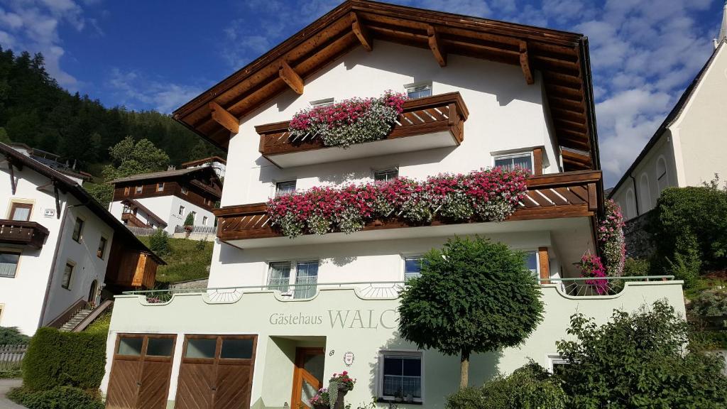 un edificio blanco con cajas de flores. en Gästehaus Walch, en Fendels