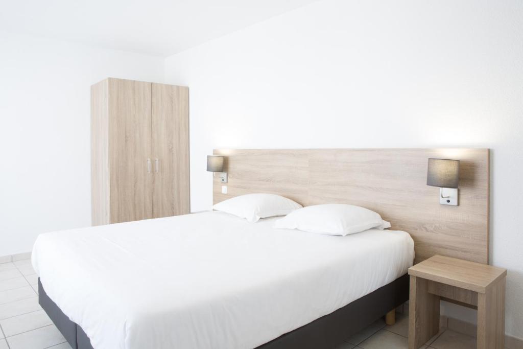 Säng eller sängar i ett rum på Zenitude Hôtel-Résidences La Versoix