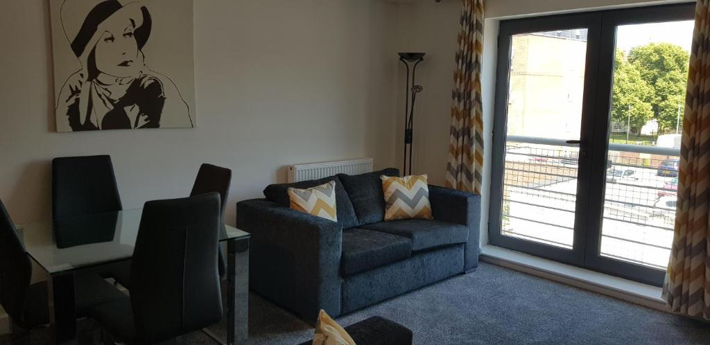 a living room with a couch and a chair and a window at Horseshoe Apartments in Portsmouth