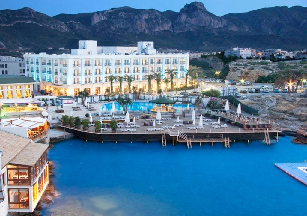 Blick auf ein Hotel mit einer Anlegestelle im Wasser in der Unterkunft Rocks Hotel & Casino in Kyrenia