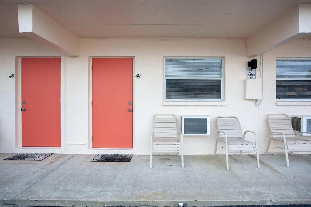 a building with two red doors and two chairs at Venice Villas * Studio #49 in Venice