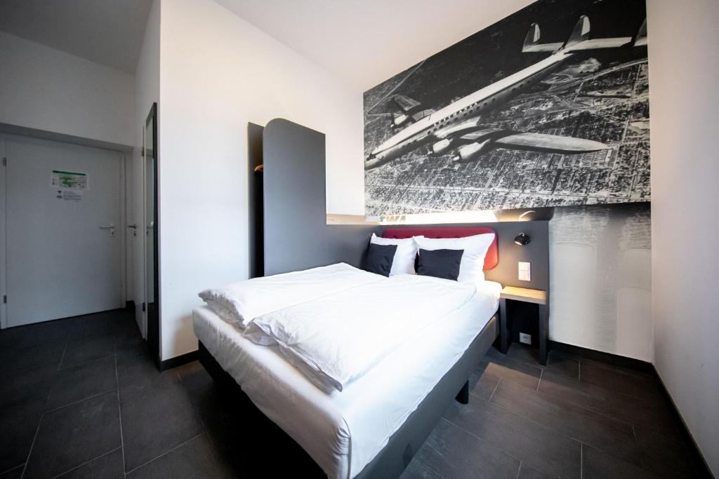 Postel nebo postele na pokoji v ubytování SMARTY Airport Cologne Hotel - KONTAKTLOSER SELF CHECK-IN