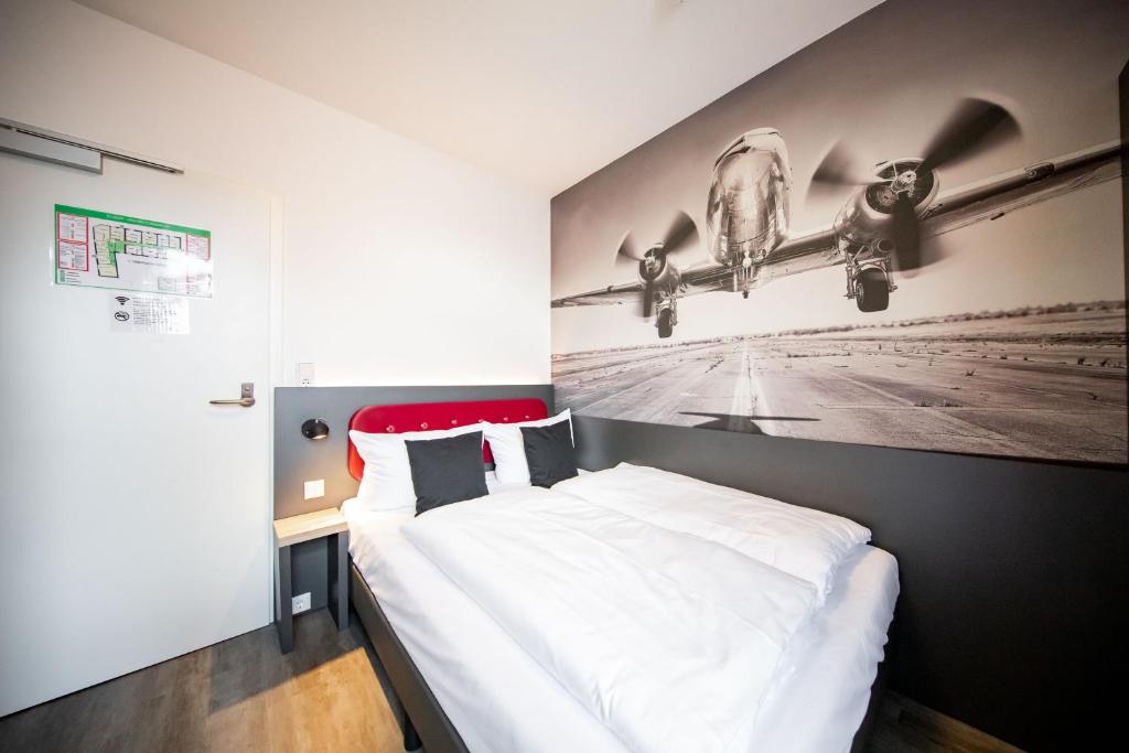 Postel nebo postele na pokoji v ubytování SMARTY Airport Cologne Hotel - KONTAKTLOSER SELF CHECK-IN