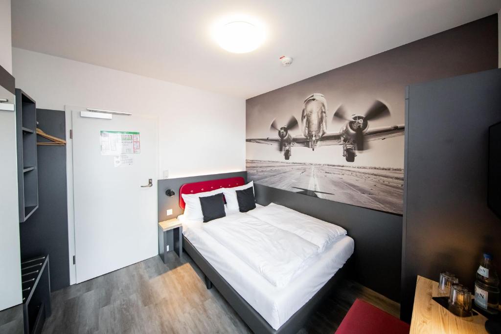 Postel nebo postele na pokoji v ubytování SMARTY Airport Cologne Hotel - KONTAKTLOSER SELF CHECK-IN