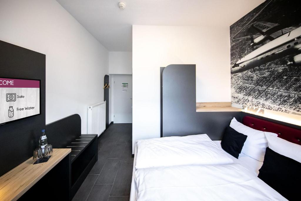 Postel nebo postele na pokoji v ubytování SMARTY Airport Cologne Hotel - KONTAKTLOSER SELF CHECK-IN
