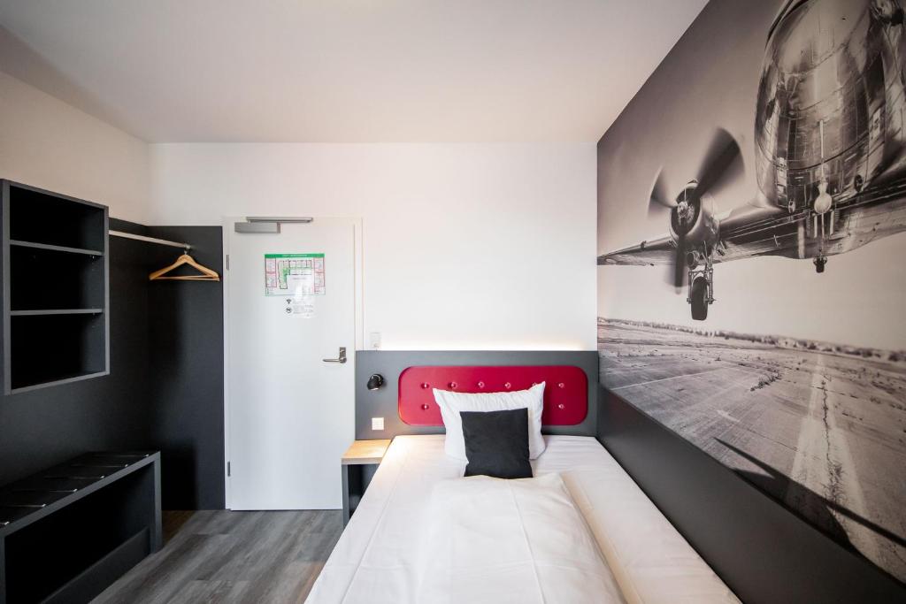 Postel nebo postele na pokoji v ubytování SMARTY Airport Cologne Hotel - KONTAKTLOSER SELF CHECK-IN