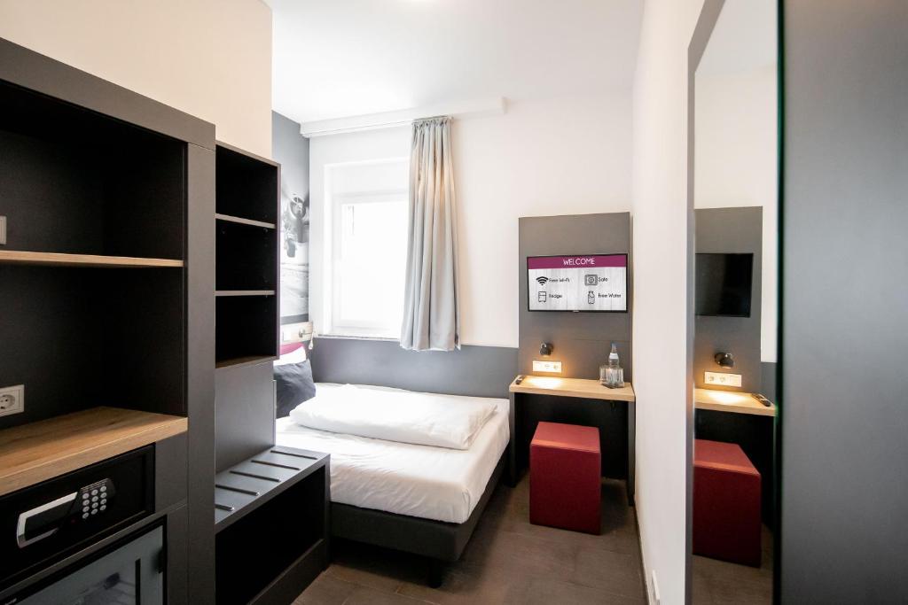 Postel nebo postele na pokoji v ubytování SMARTY Airport Cologne Hotel - KONTAKTLOSER SELF CHECK-IN