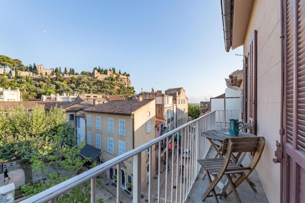 un balcon avec une table et une vue sur une ville dans l'établissement Le Central par Dodo-a-Cassis, à Cassis