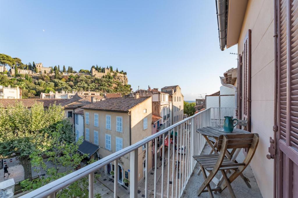 a balcony with a table and a view of a city at Le Central par Dodo-a-Cassis in Cassis