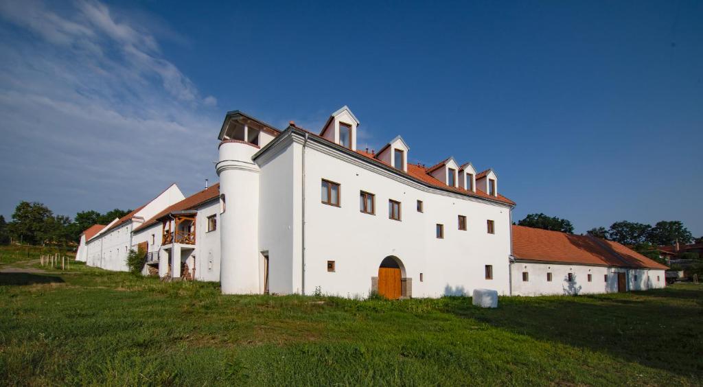 a large white building on a grassy field at Residence Tvrz Skočice in Skočice