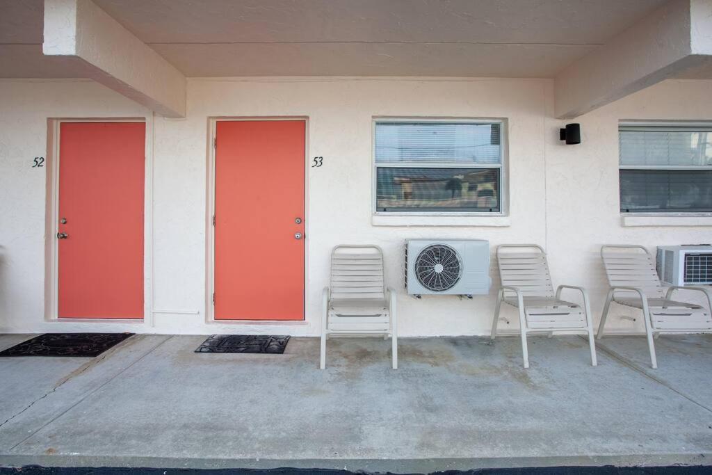a building with two red doors and chairs and a fan at Venice Villas * Studio #53 in Venice