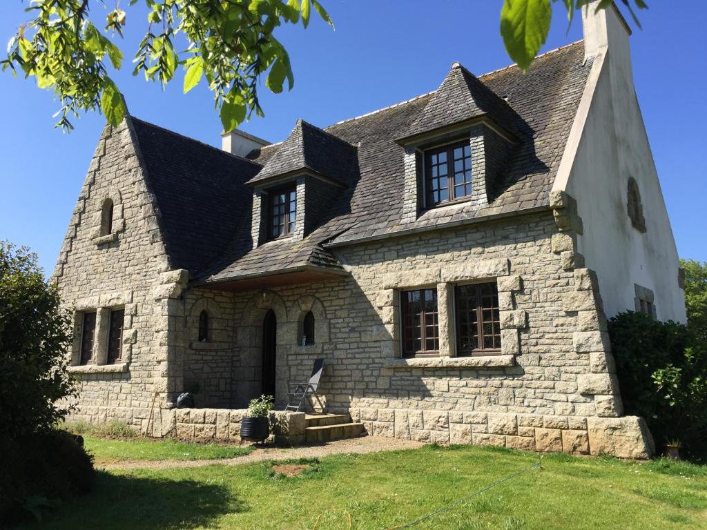 uma antiga casa de pedra com um telhado preto em Les Chambres de KERCHELGEN em Saint-Sauveur
