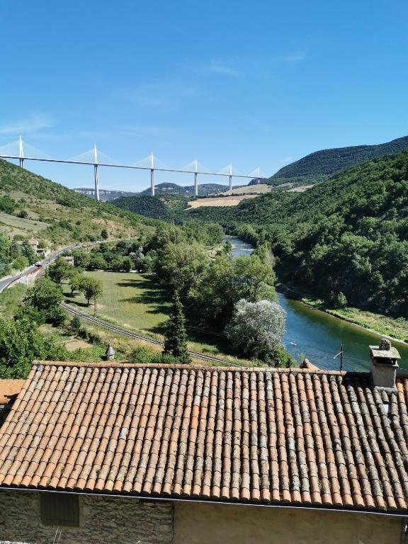 a view of a river with a bridge in the background at La Terrasse de Peyre in Comprégnac