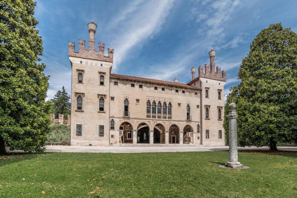 a large brick building with two towers on top at Castello di Thiene in Thiene