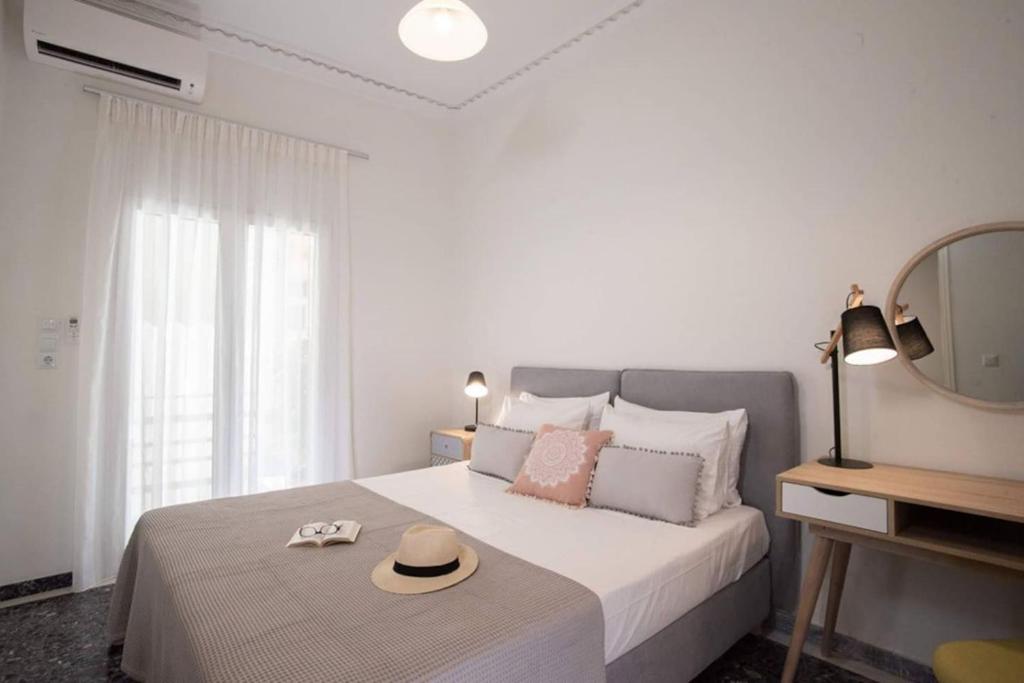 - une chambre avec un lit avec un chapeau et un miroir dans l'établissement Hellona house ,sunny and cozy apartment's, à Nauplie