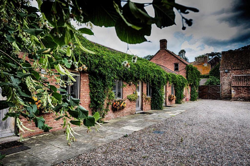 een stenen gebouw met klimop erop bij Maunsel House in North Newton