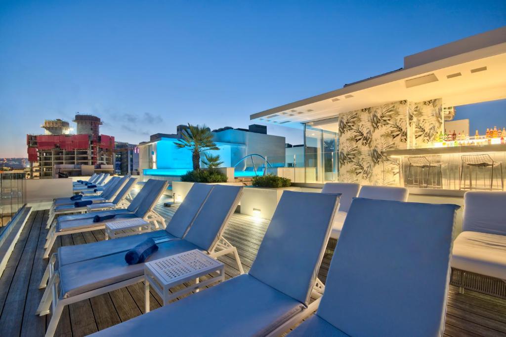 a row of chairs on the roof of a building at Hotel Valentina in St. Julianʼs