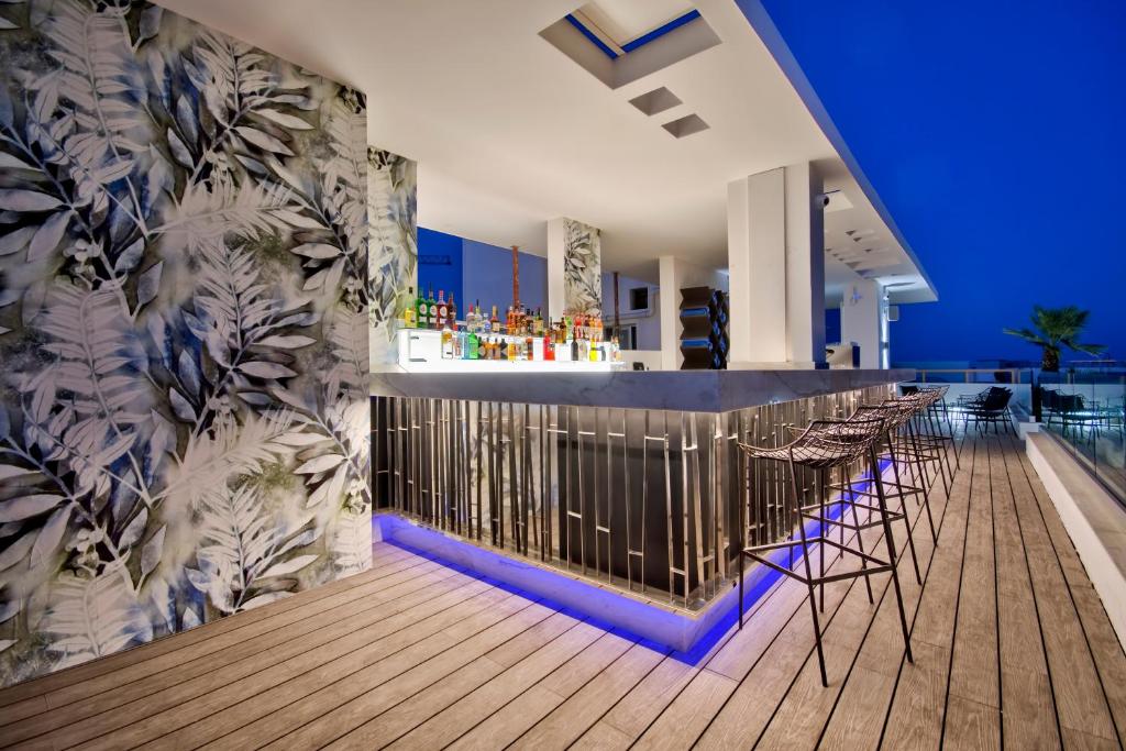 a bar on the roof of a building with chairs at Hotel Valentina in St. Julianʼs