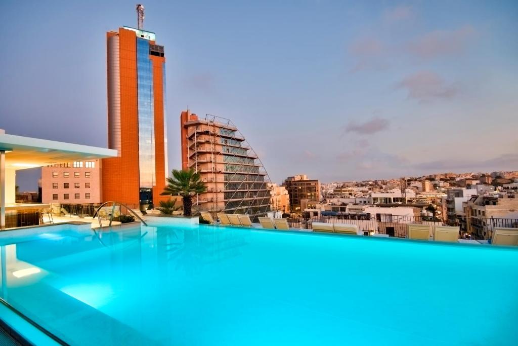 a swimming pool on the roof of a building at Hotel Valentina in St. Julianʼs
