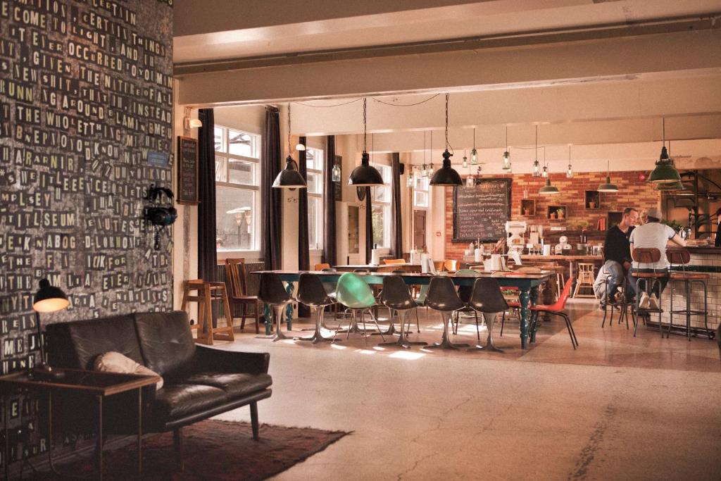 een kamer met een tafel en stoelen en mensen in een restaurant bij Kex Hostel in Reykjavík