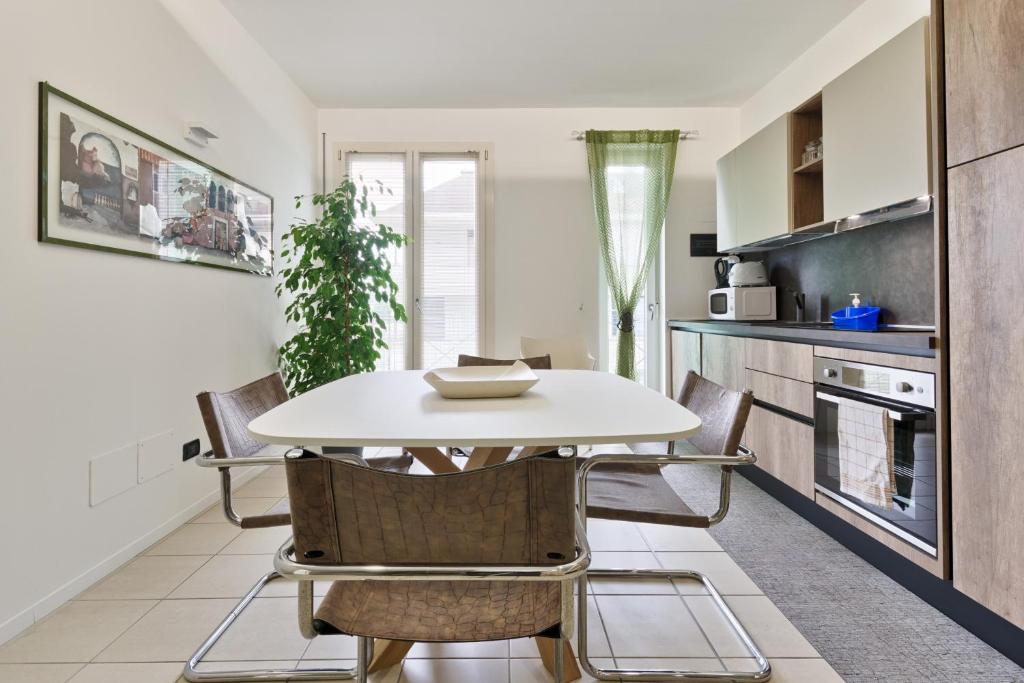 CASA AURORA في فيتشنزا: مطبخ وغرفة طعام مع طاولة وكراسي