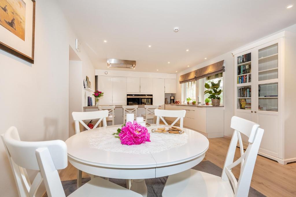 una cucina e una sala da pranzo con tavolo e sedie bianchi di Modern Apartment with panorama wiew a Blakset