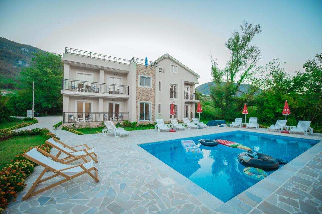 ein Haus mit einem Pool vor einem Haus in der Unterkunft Apartment Vrutak in Kotor