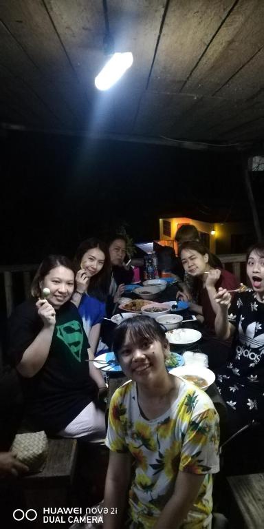 Ban ThungBondoilampang的一群人坐在房间里的桌子旁