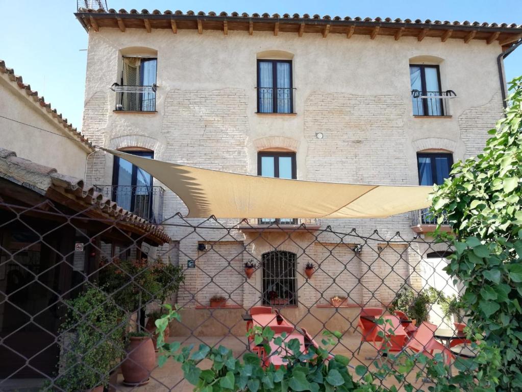 a building behind a fence in front at Apartamentos La Venta del Rome in Horta de San Joan