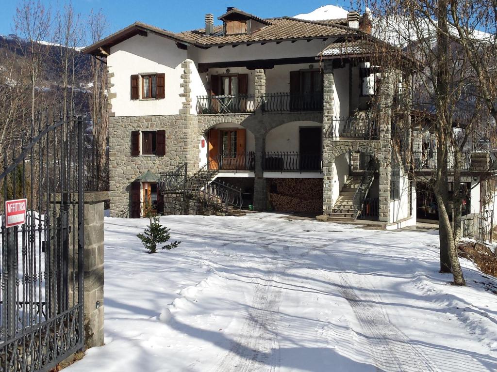 uma casa na neve com uma cerca em Il Puntone em Fiumalbo