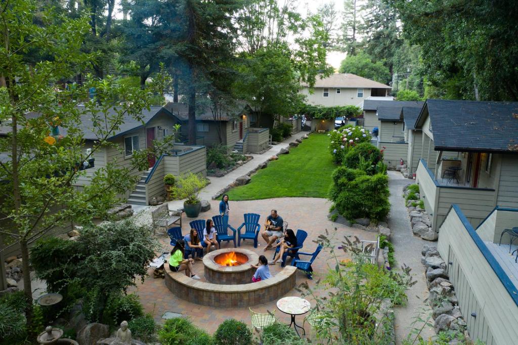 a group of people sitting around a fire pit in a yard at Cottages On River Road in Guerneville