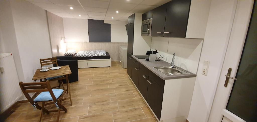 eine kleine Küche mit einem Waschbecken und einem Tisch in der Unterkunft Welcome Apartment Cölbe in Cölbe