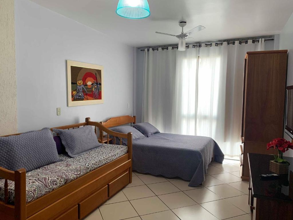 a bedroom with a bed and a couch at Loft Prainha em Arraial Do Cabo in Arraial do Cabo