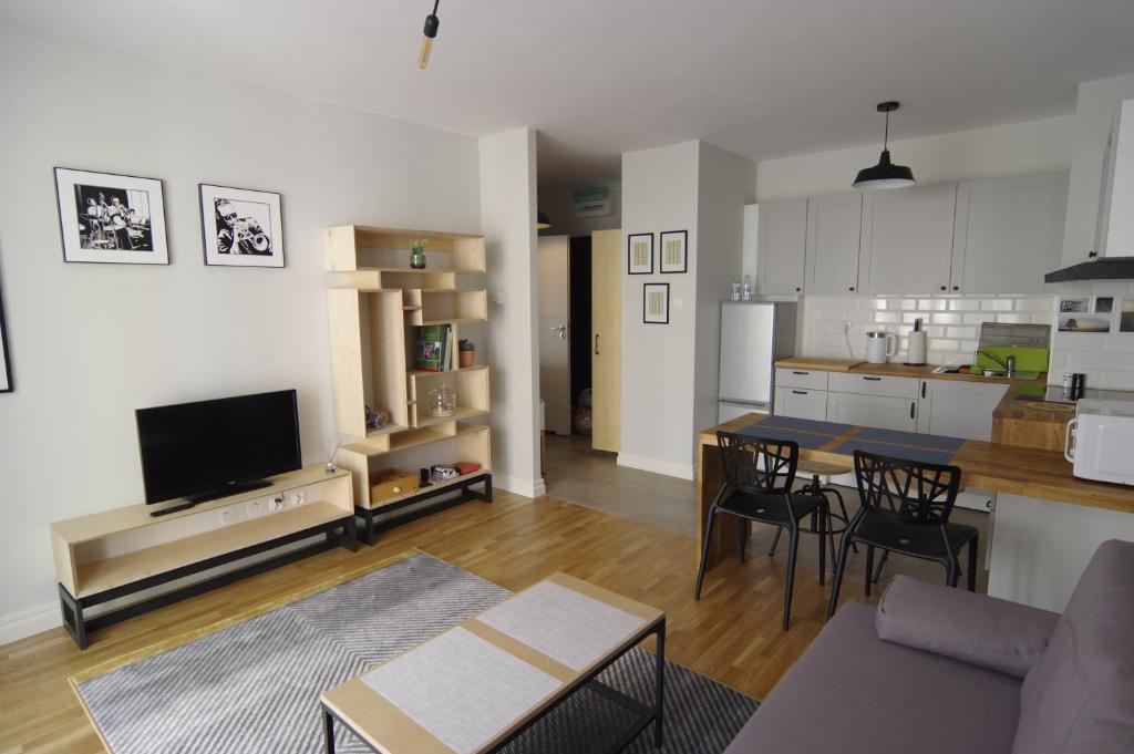 a kitchen and a living room with a table and chairs at Apartament 5e in Szczecin