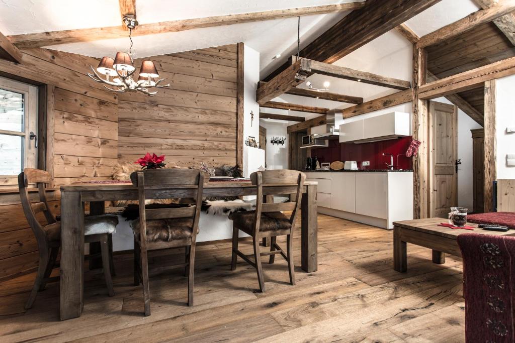 - une cuisine et une salle à manger avec une table et des chaises dans l'établissement Uralp Royal by A-Appartments, à Brand