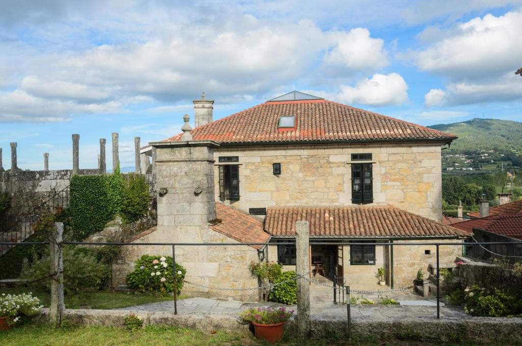 an old stone house with a red roof at Hotel A Torre do Xudeu in Tui