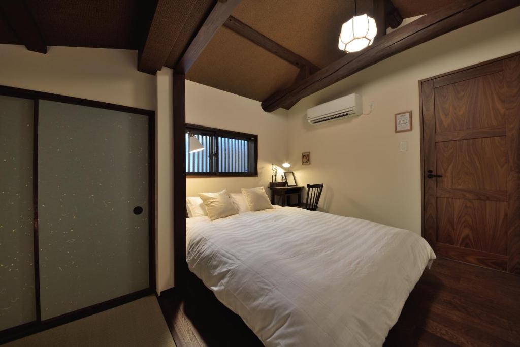 una camera con un letto bianco e una porta in legno di Kyoto - House / Vacation STAY 43525 a Kyoto