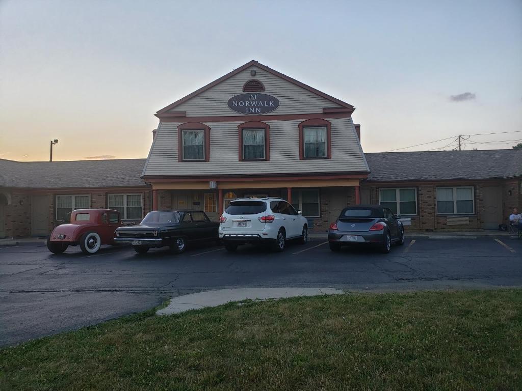 a building with cars parked in a parking lot at Norwalk Inn in Norwalk