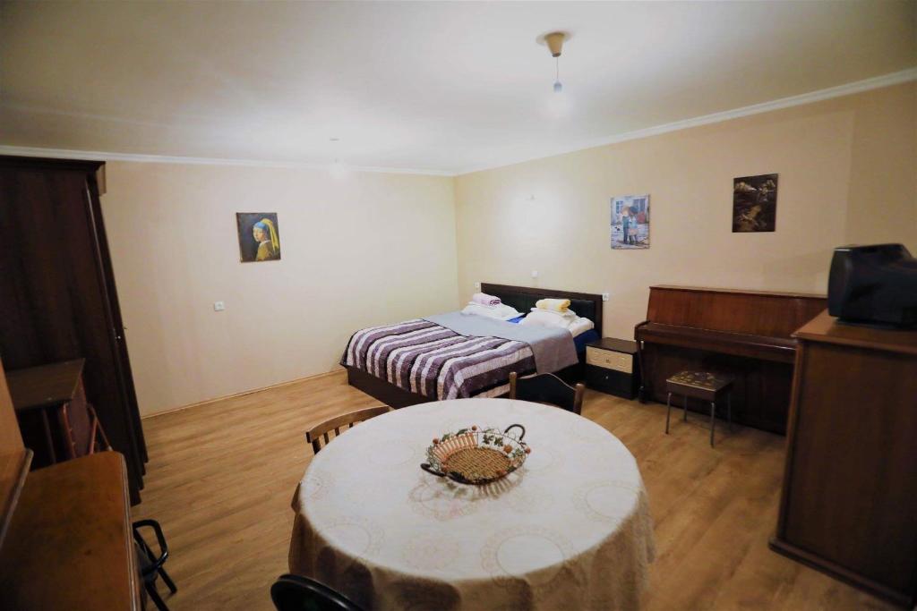 a room with a bed and a table and a piano at cozy and warm in Tbilisi City