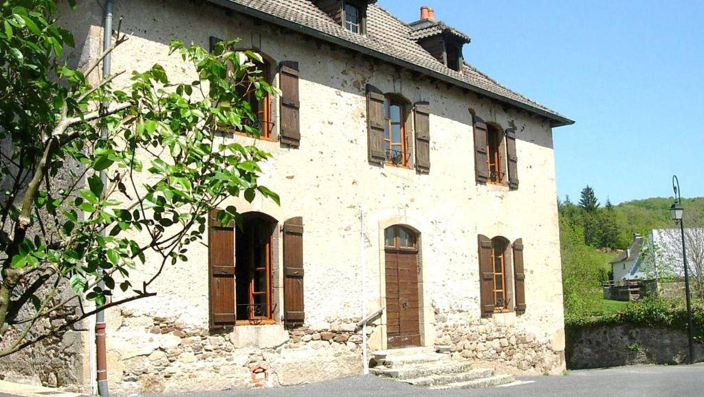 ein altes Steingebäude mit seitlichen Fenstern in der Unterkunft Les gîtes du bourg in Vitrac